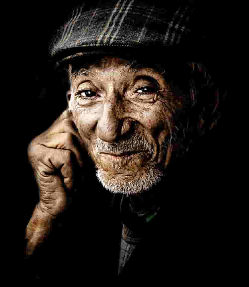 A man with a hat is talking on his cell phone