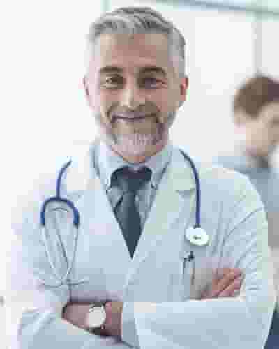 A man in a doctor 's uniform is smiling.