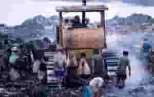 A train is traveling down the tracks near mountains.