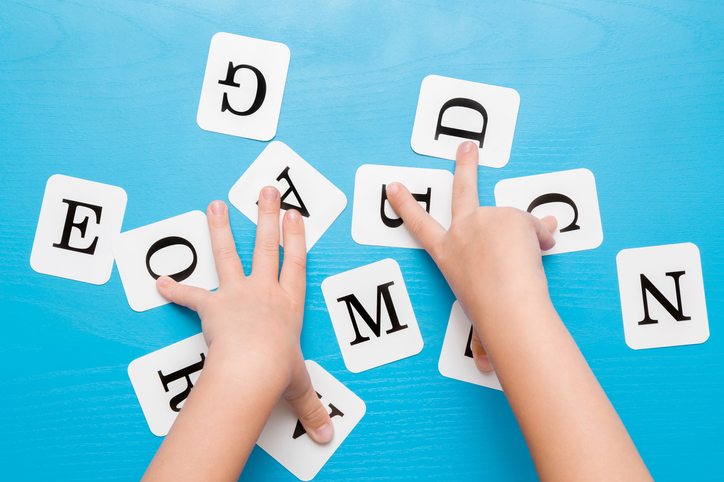 A person is playing with letters on the table