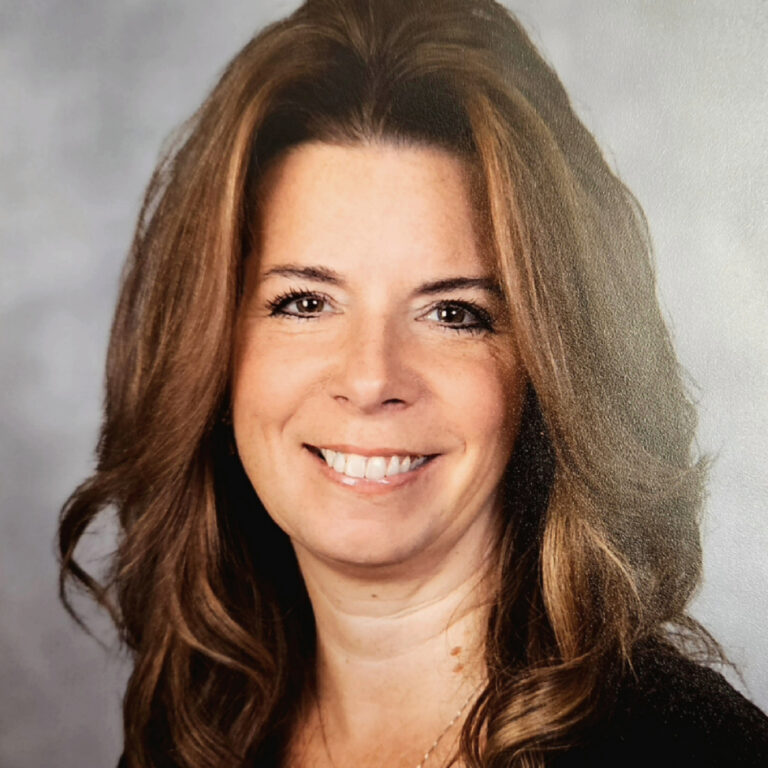 A woman with long hair smiles for the camera.