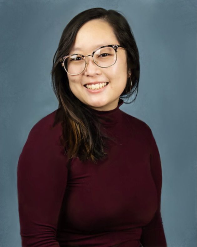 A woman in glasses and a maroon shirt