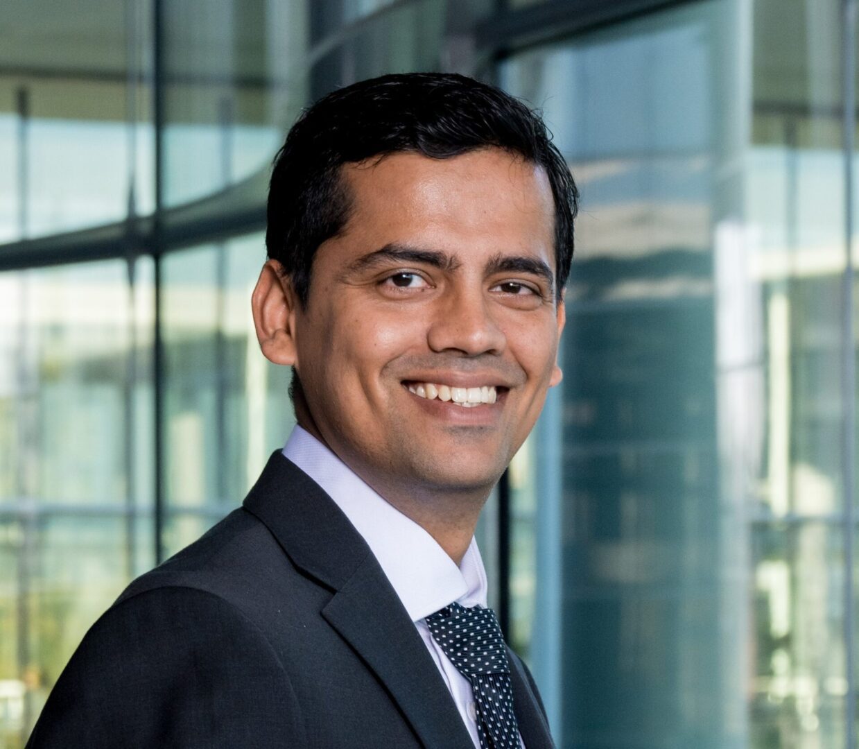 A man in suit and tie smiling for the camera.